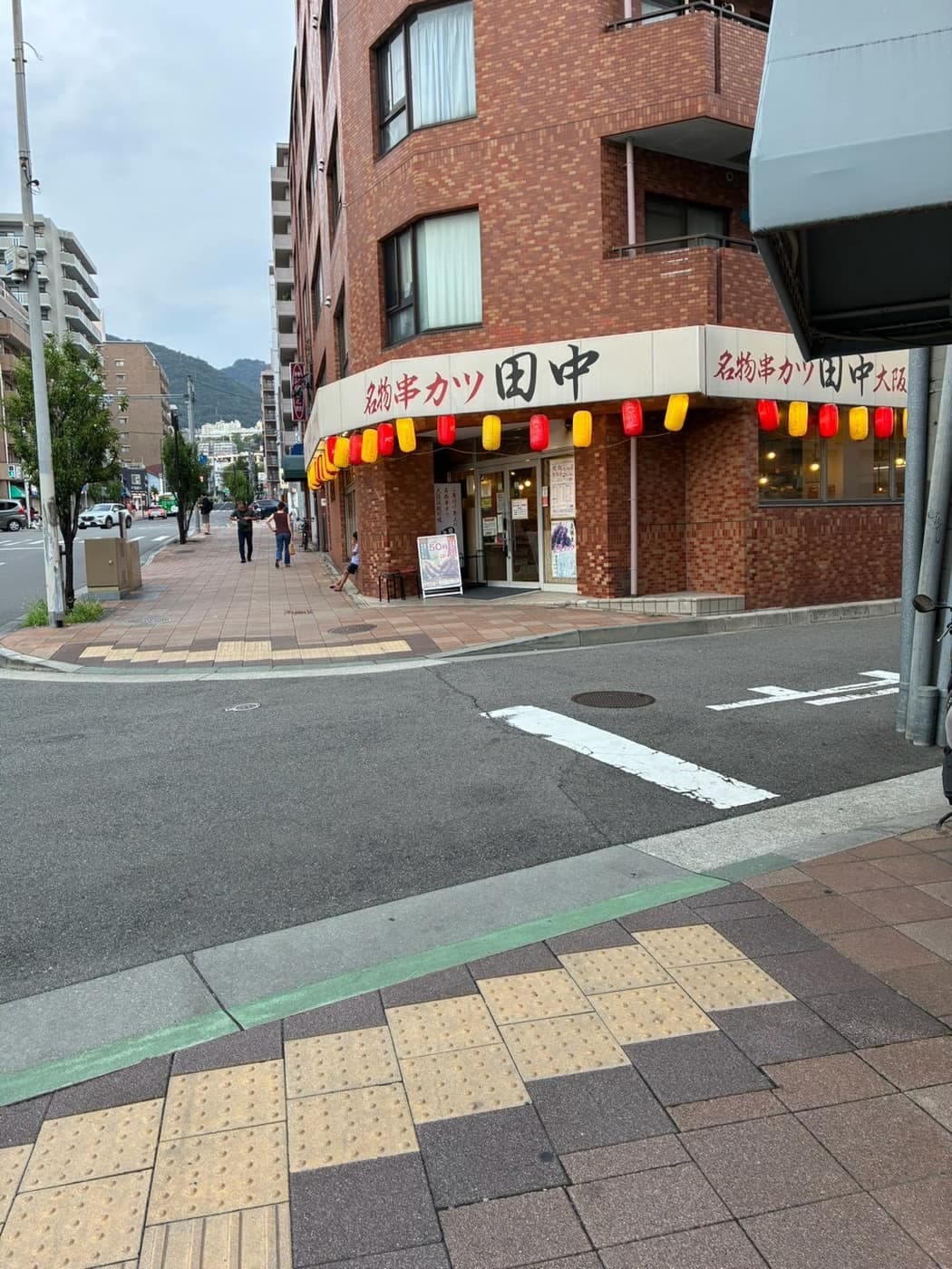 赤レンガの建物にある「串カツ田中」の看板と、右へ曲がる角